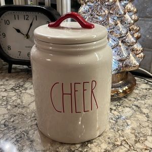 Rae Dunn canister labeled CHEER.  White with red lettering and red trim on lid